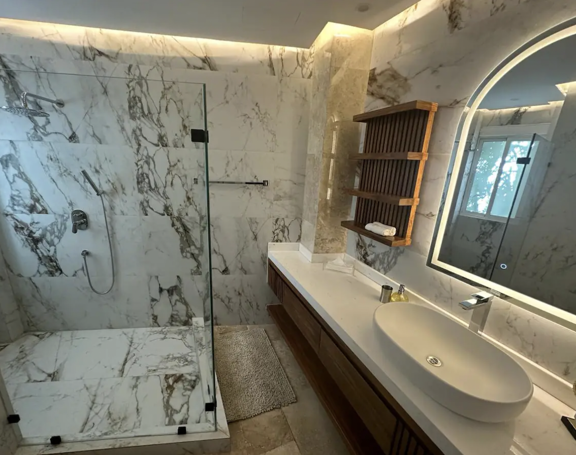 Master bathroom with marble finishes, glass shower and large vanity in Isla Mujeres