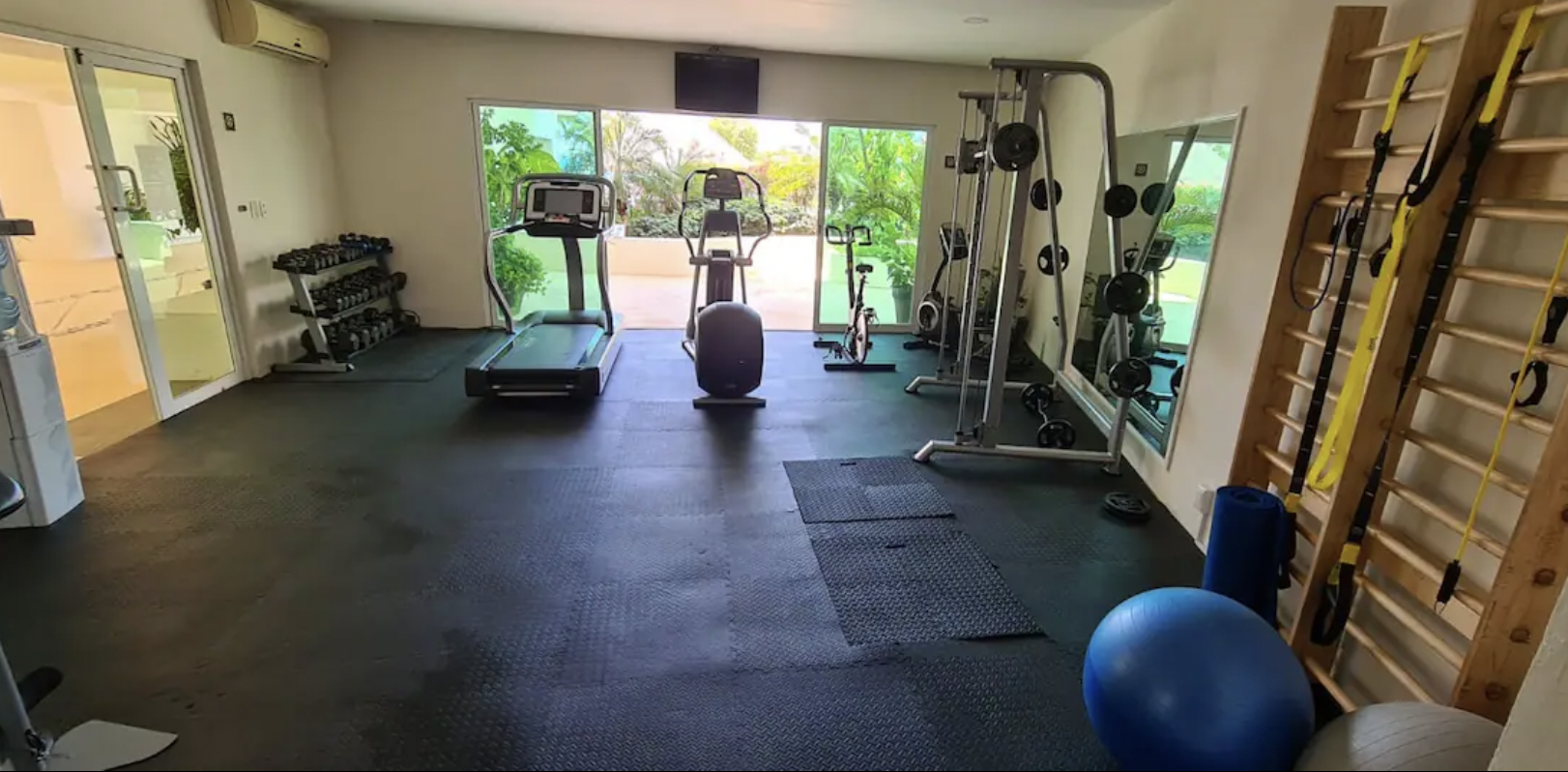 Fully equipped gym with treadmill, elliptical and weights at the condo
