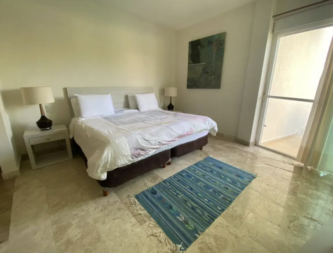 Third bedroom with two twin beds opening to balcony, ideal for families in Isla Mujeres
