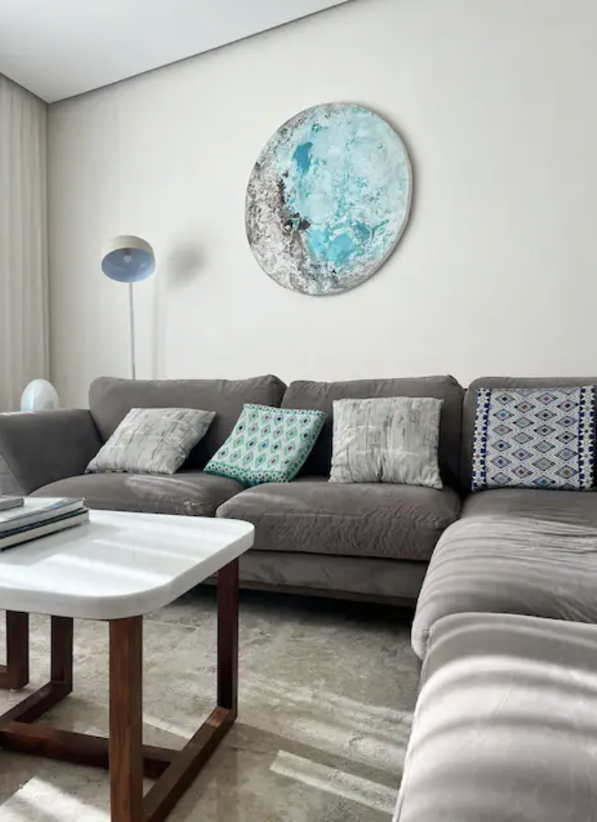 Living room with gray sofa, artisan cushions and turquoise wall art