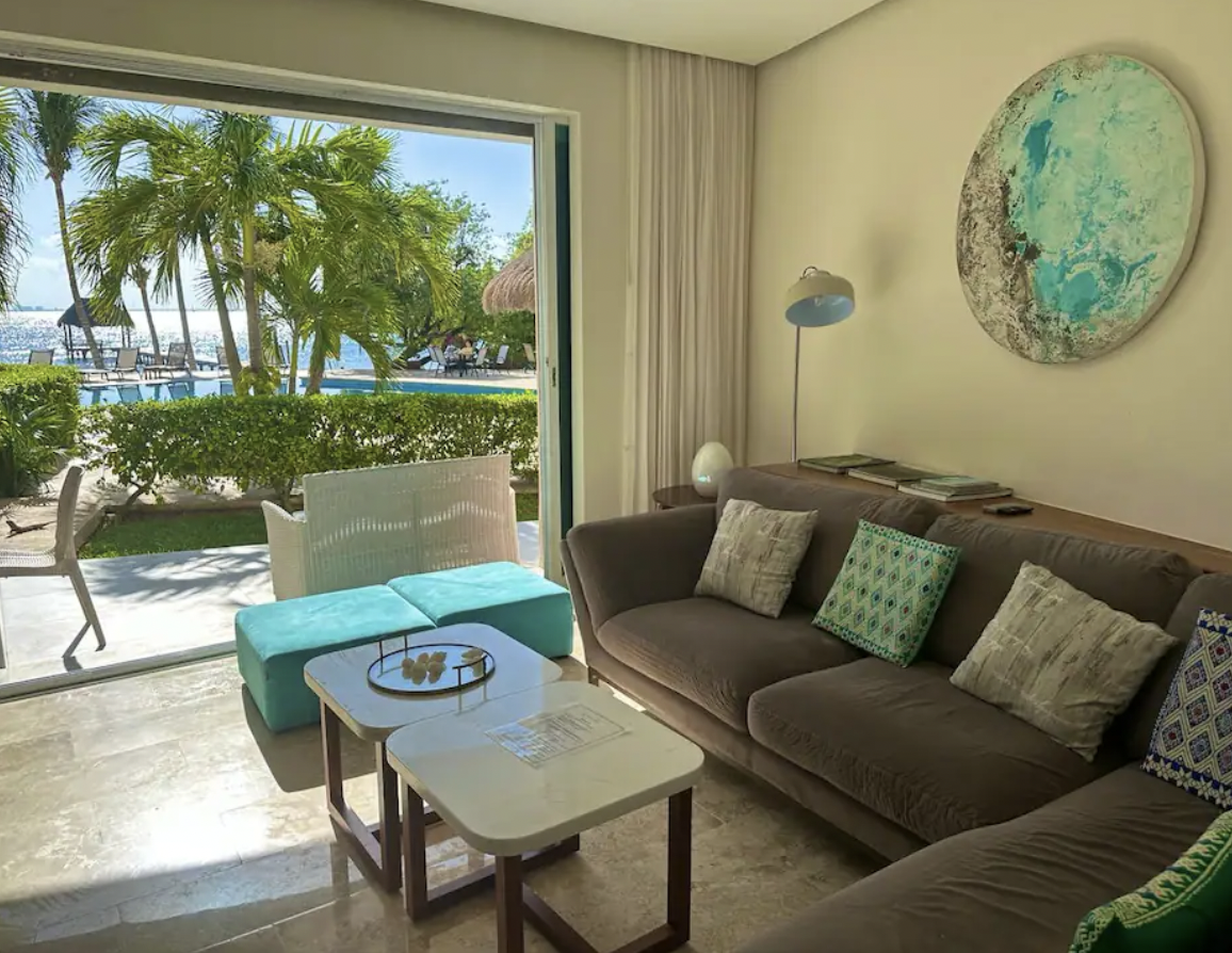 Living room with direct pool and palm view through the picture window