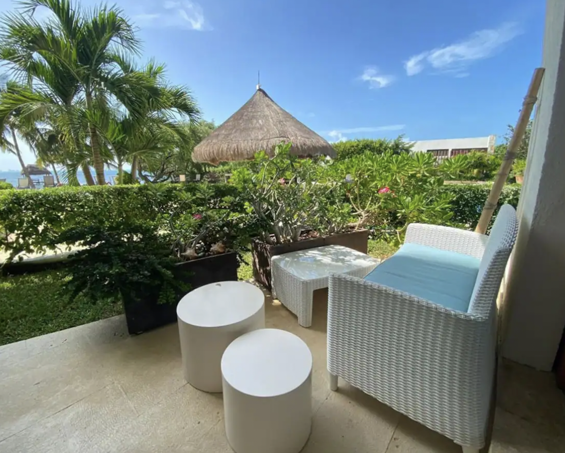 Outdoor lounge on private terrace with tropical garden and beachfront palapa in Isla Mujeres