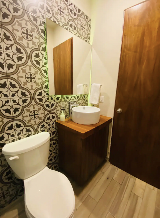 Full bathroom with black-and-white talavera tile and round sink at Villa La Ceiba