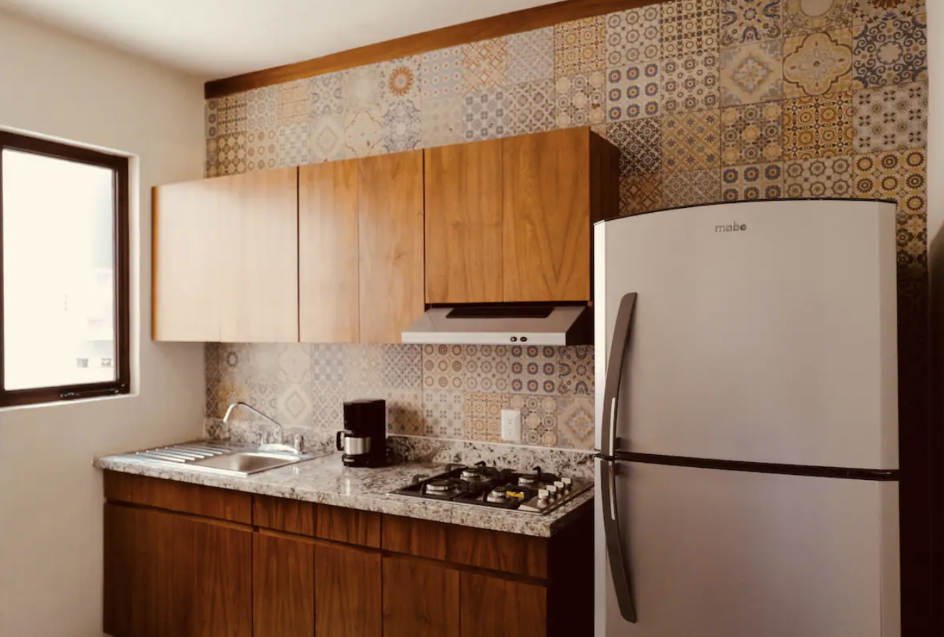 Equipped kitchen with talavera tile, Mabe fridge and gas stove at Villa La Ceiba