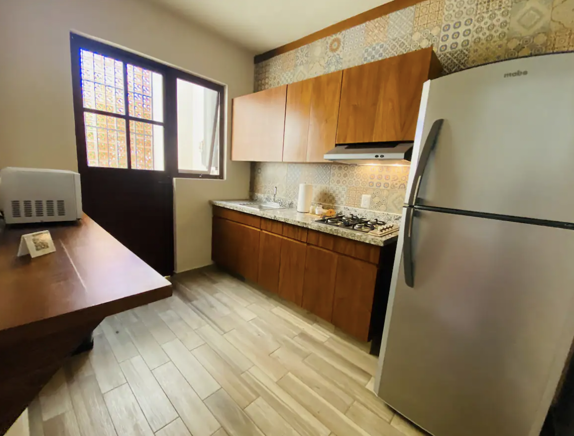 Equipped kitchen with talavera tile and Mabe refrigerator at Villa La Ceiba