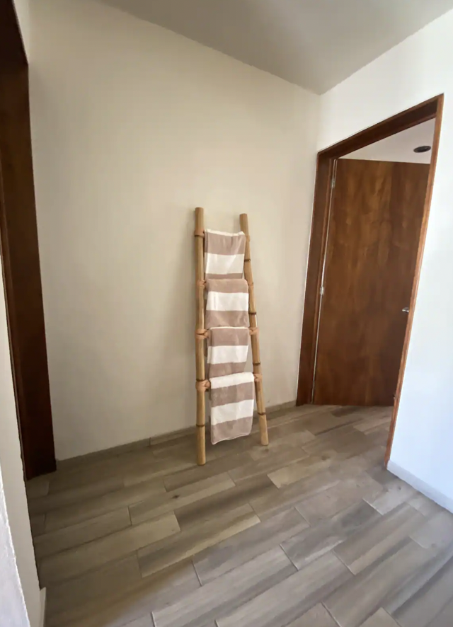Lit hallway with decorative bamboo staircase and towels at Villa La Ceiba