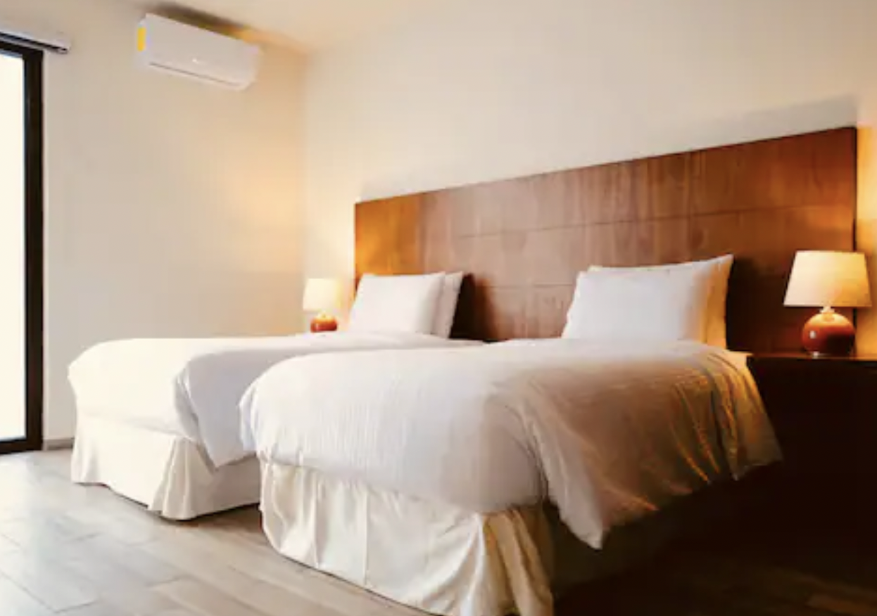 Bedroom with two twin beds, wooden headboard and air conditioning