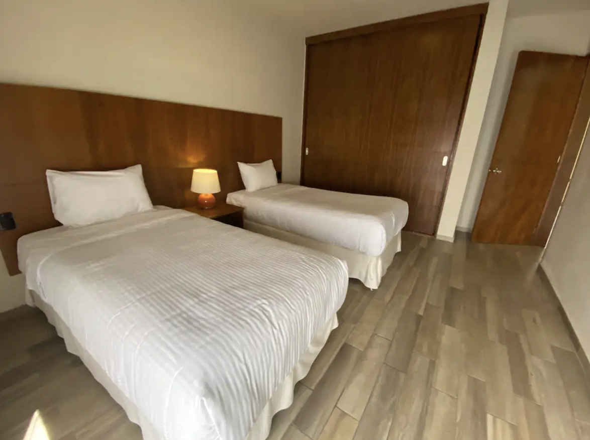 Bedroom with two twin beds and wooden closet at Villa La Ceiba, Playa del Carmen